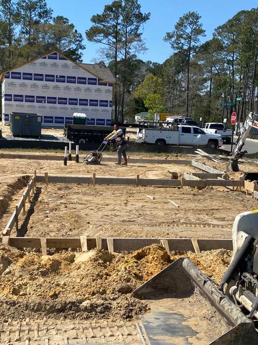 A construction site with a building in the background and a bulldozer in the foreground.