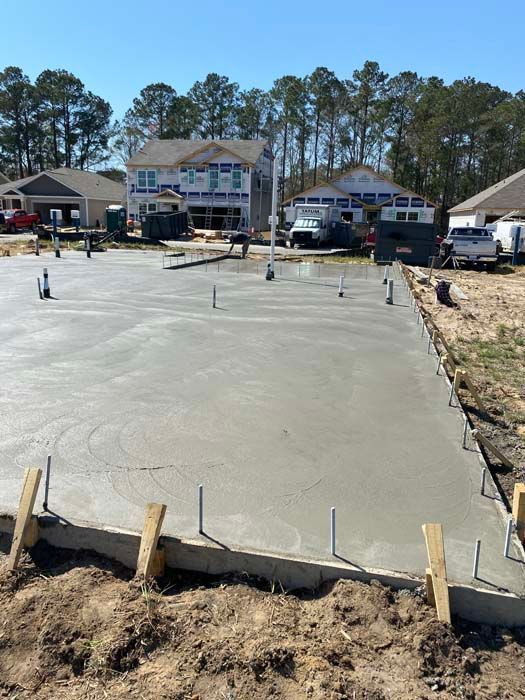A concrete foundation is being built in front of a house.