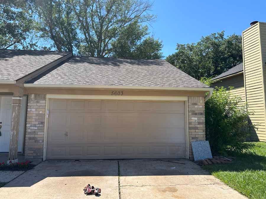 A garage door is open in front of a house.