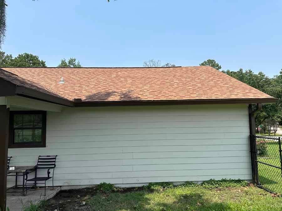 A white house with a red roof and a window.