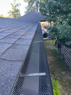 A close up of a gutter on a roof with a gutter guard.