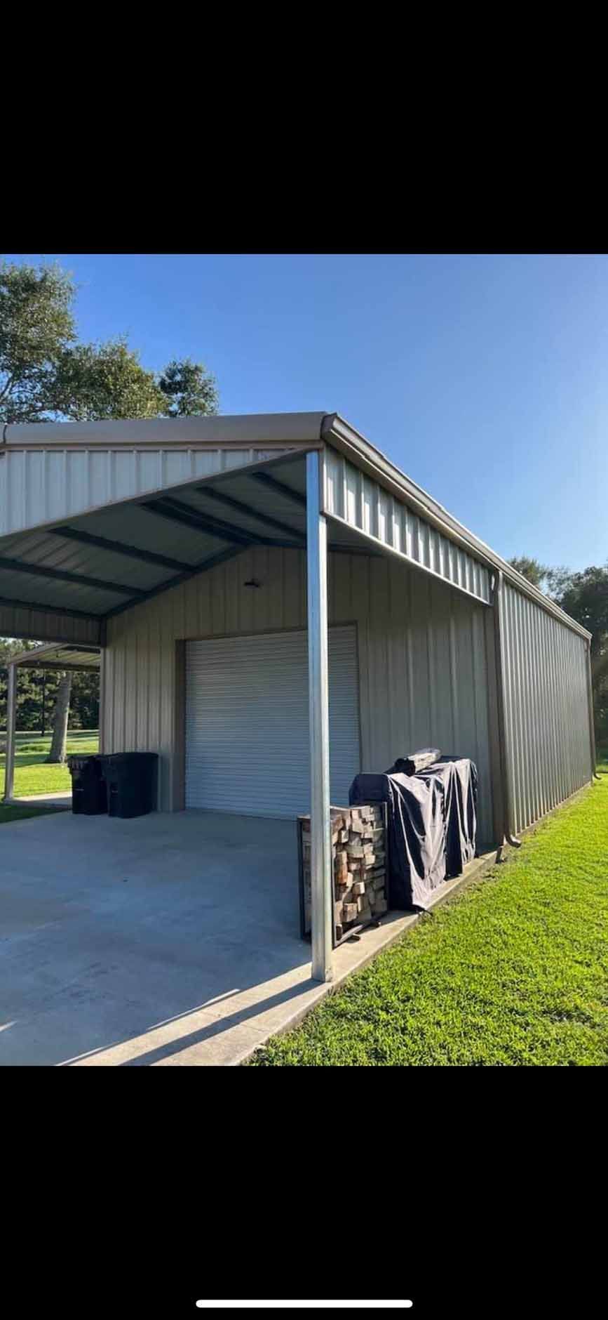 A metal garage with a covered driveway and a garage door.