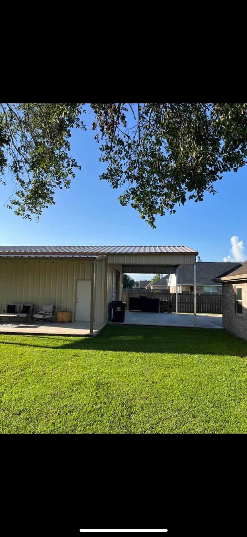 A house with a large lawn in front of it and a tree in the background.