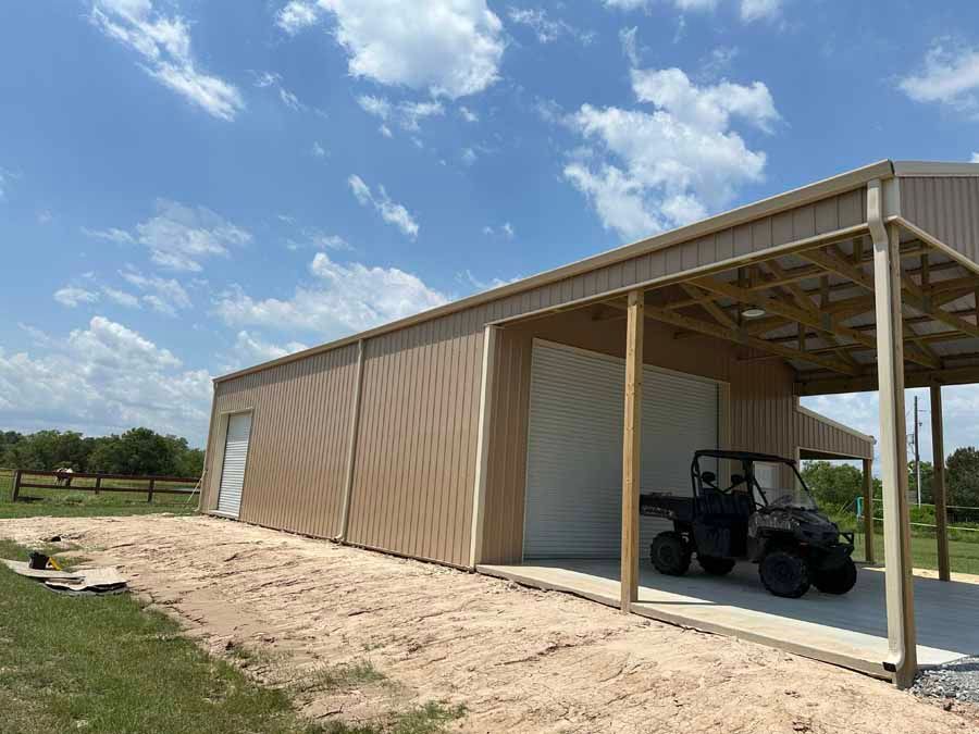 A four wheeler is parked under a canopy in a garage.