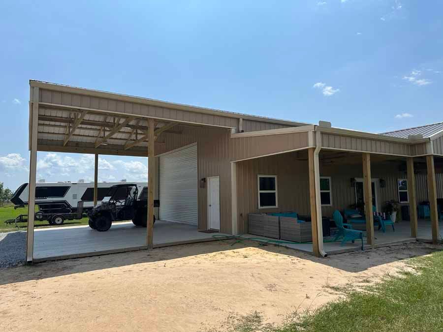 A house with a carport and a rv parked underneath it.