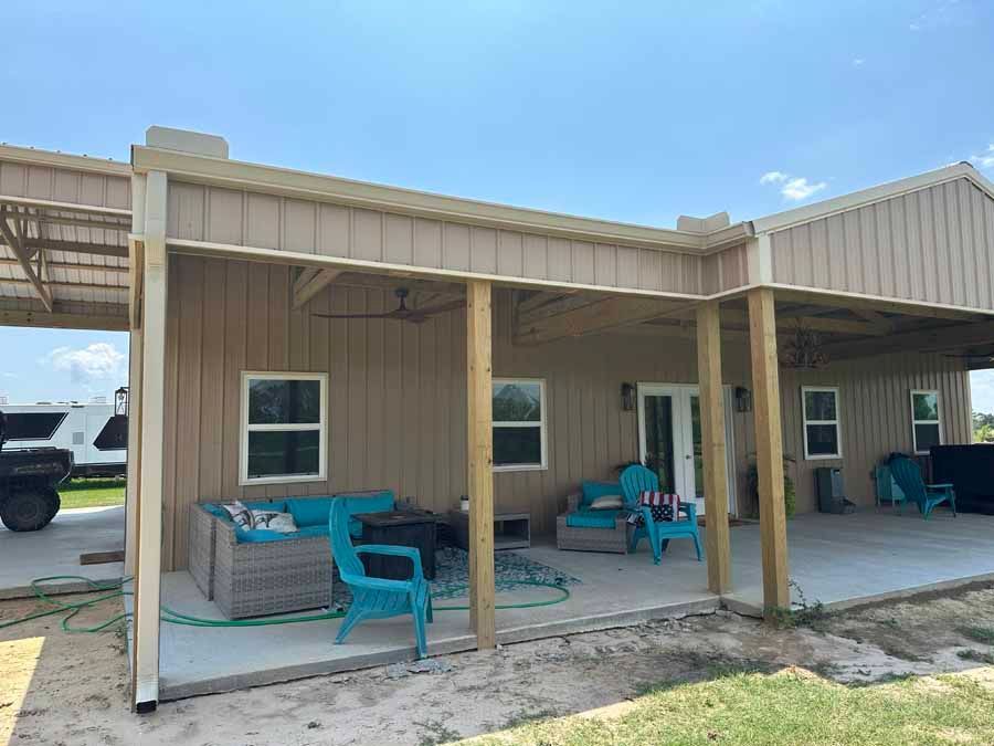 A house with a porch and a couch and chairs on it.