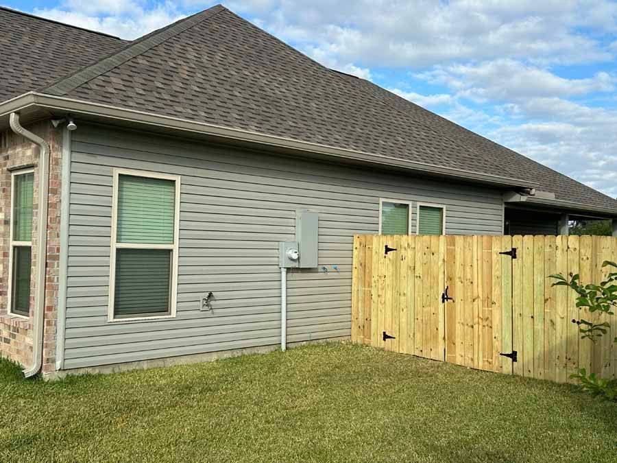 A house with a wooden fence in front of it.
