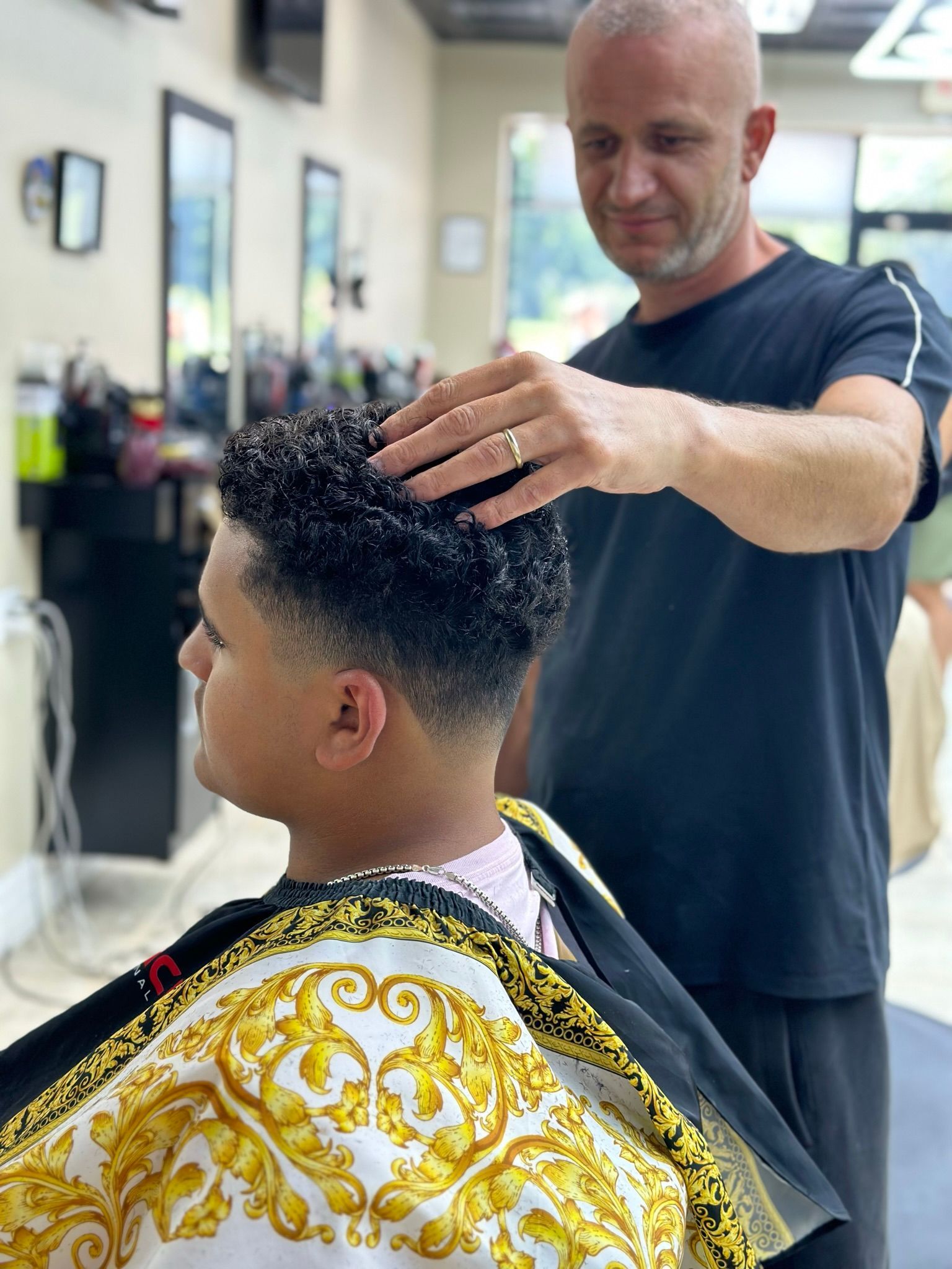 a man is cutting a man 's hair in a barber shop .