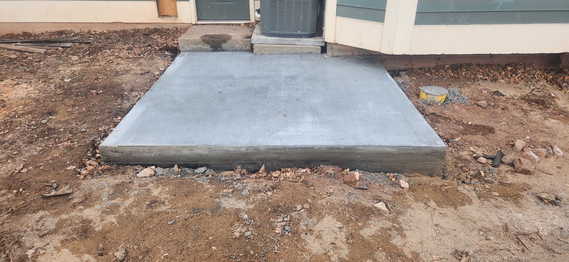 A concrete walkway is being built in front of a house.