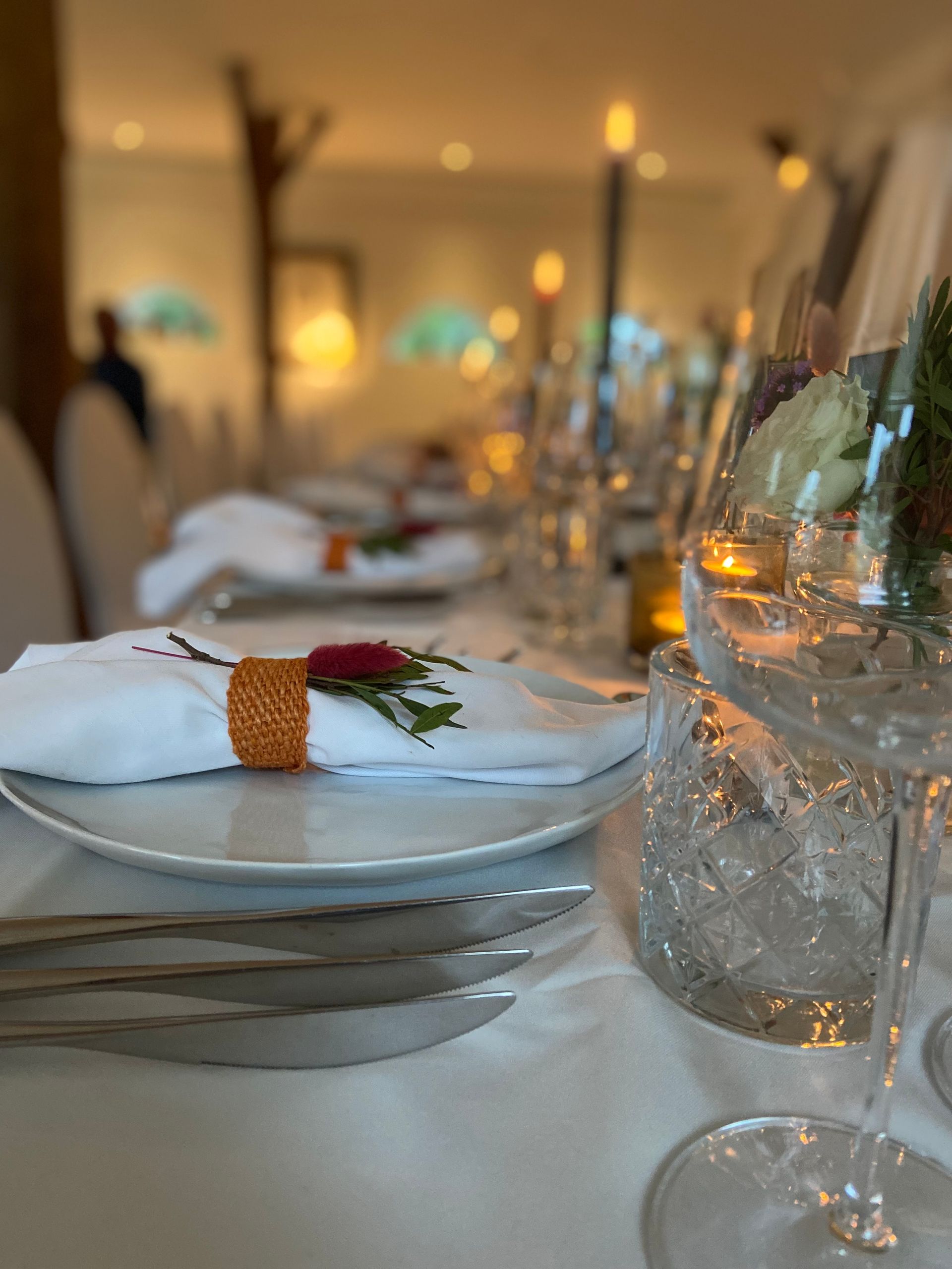 Witte borden met glaswerk en sfeervol licht in bohemian stijl bruiloft