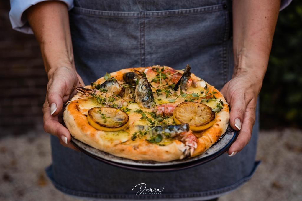 Pizza met vis door serveerster