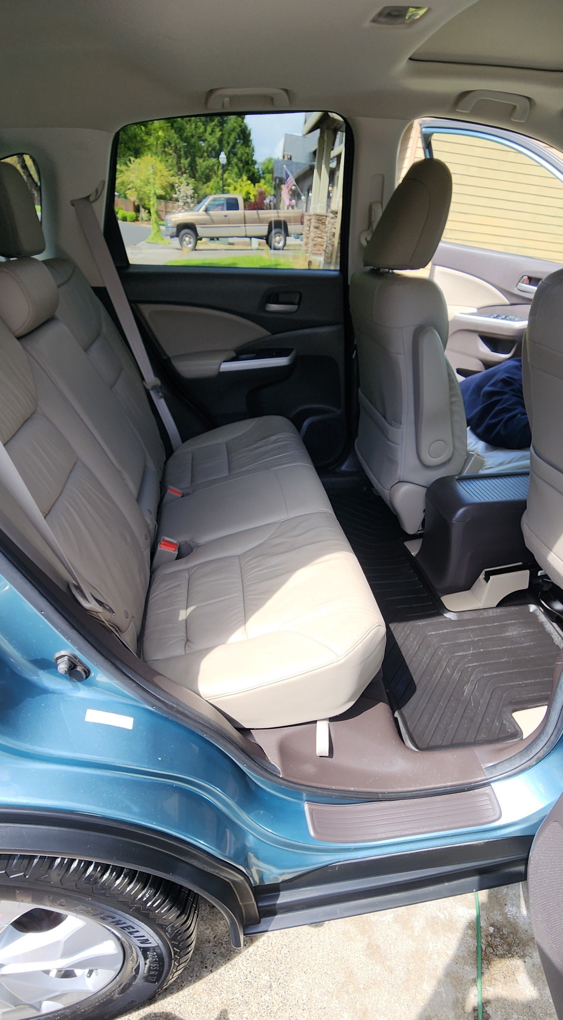 The back seat of a car is empty and dirty.