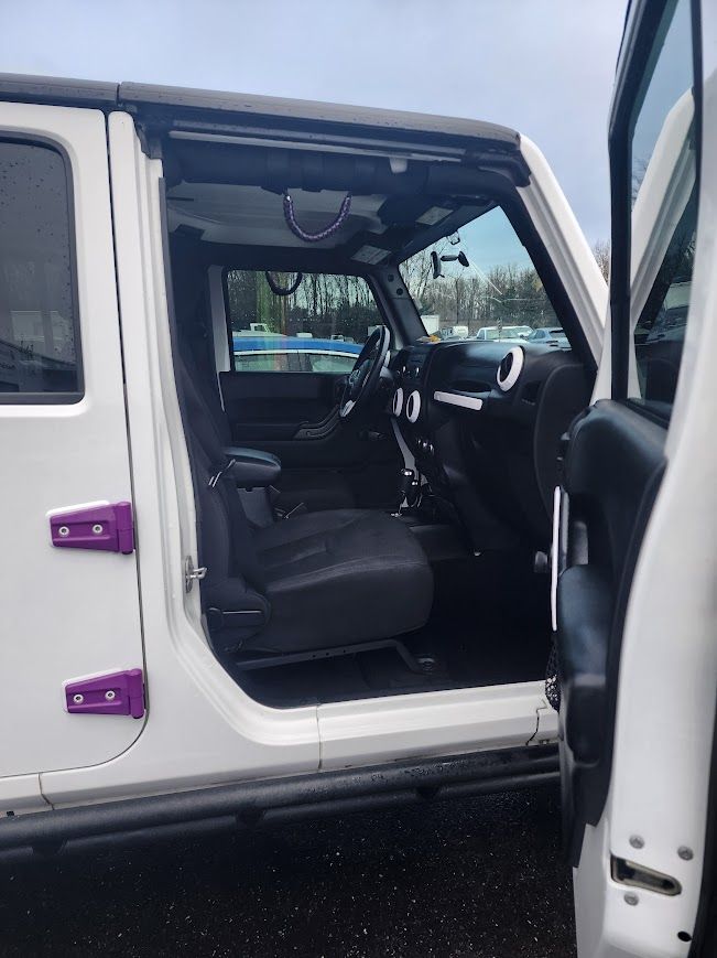 The inside of a white jeep with the door open.