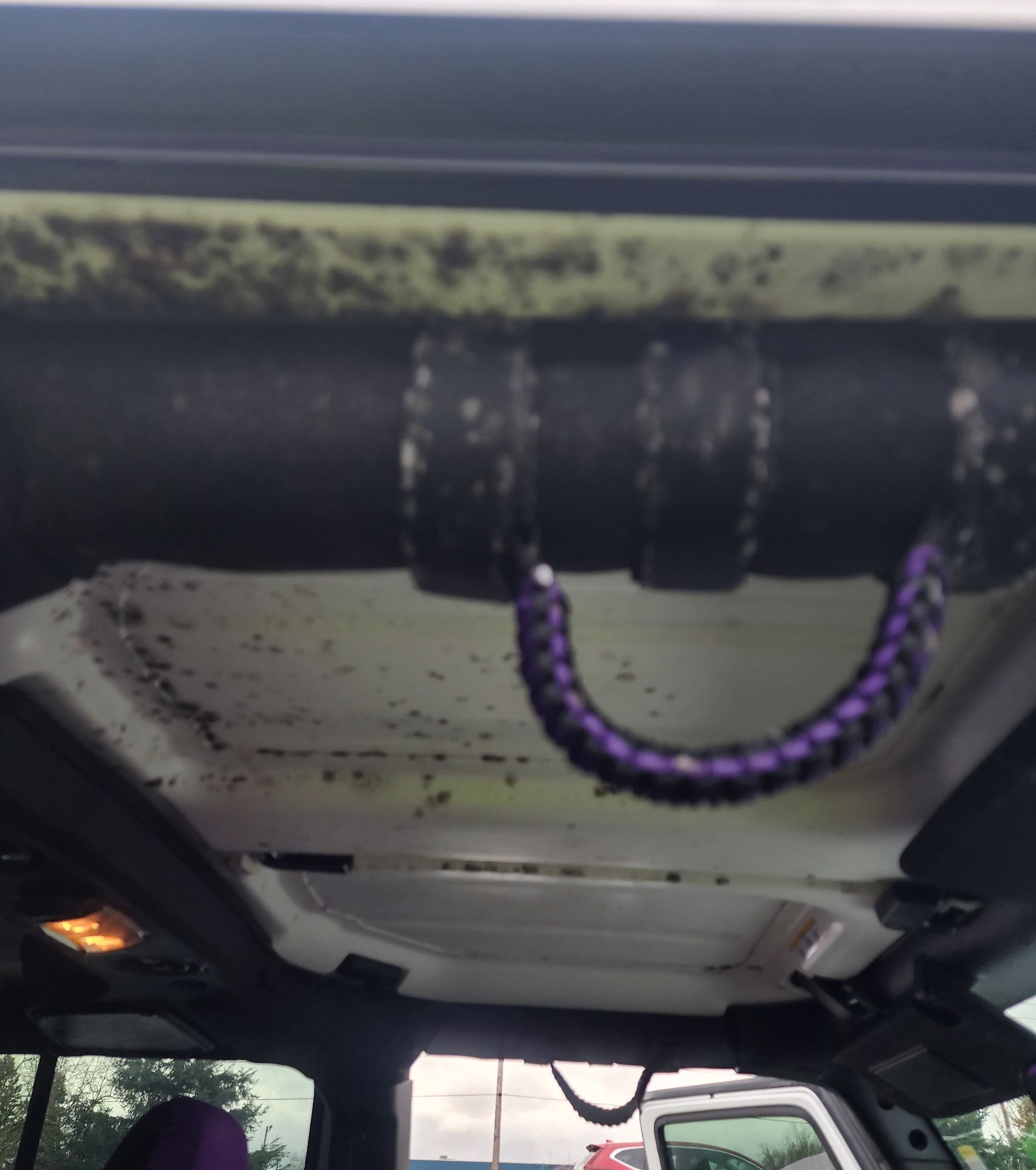 A purple rope is hanging from the ceiling of a car