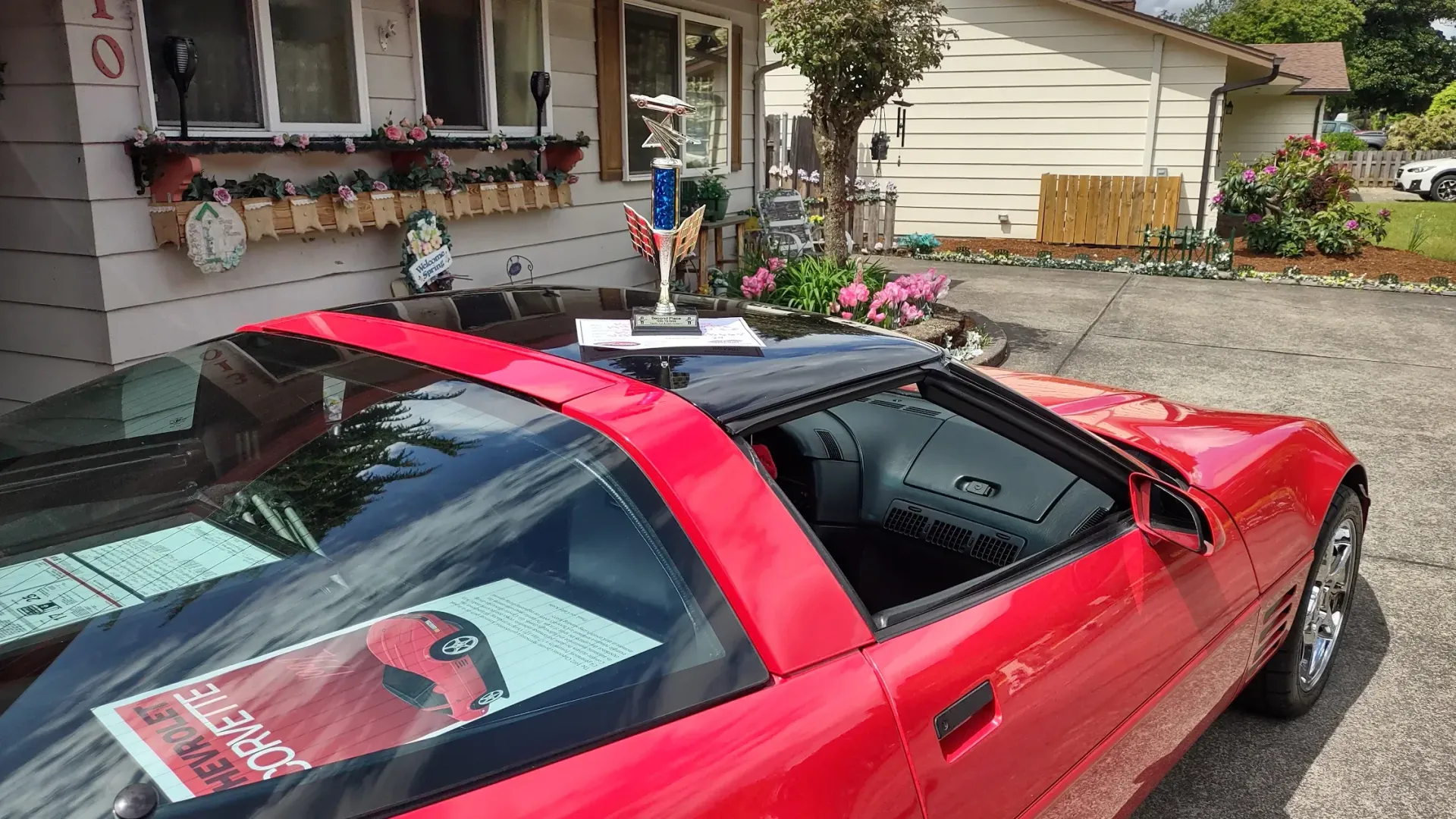 A red sports car is parked in front of a house.