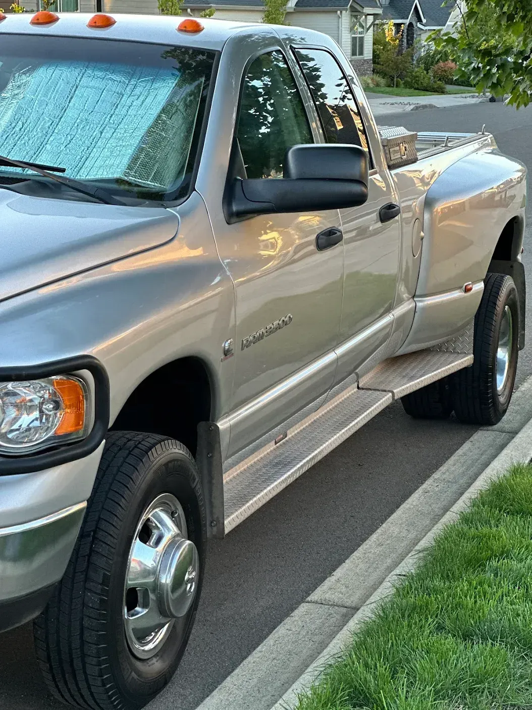 A silver truck is parked on the side of the road
