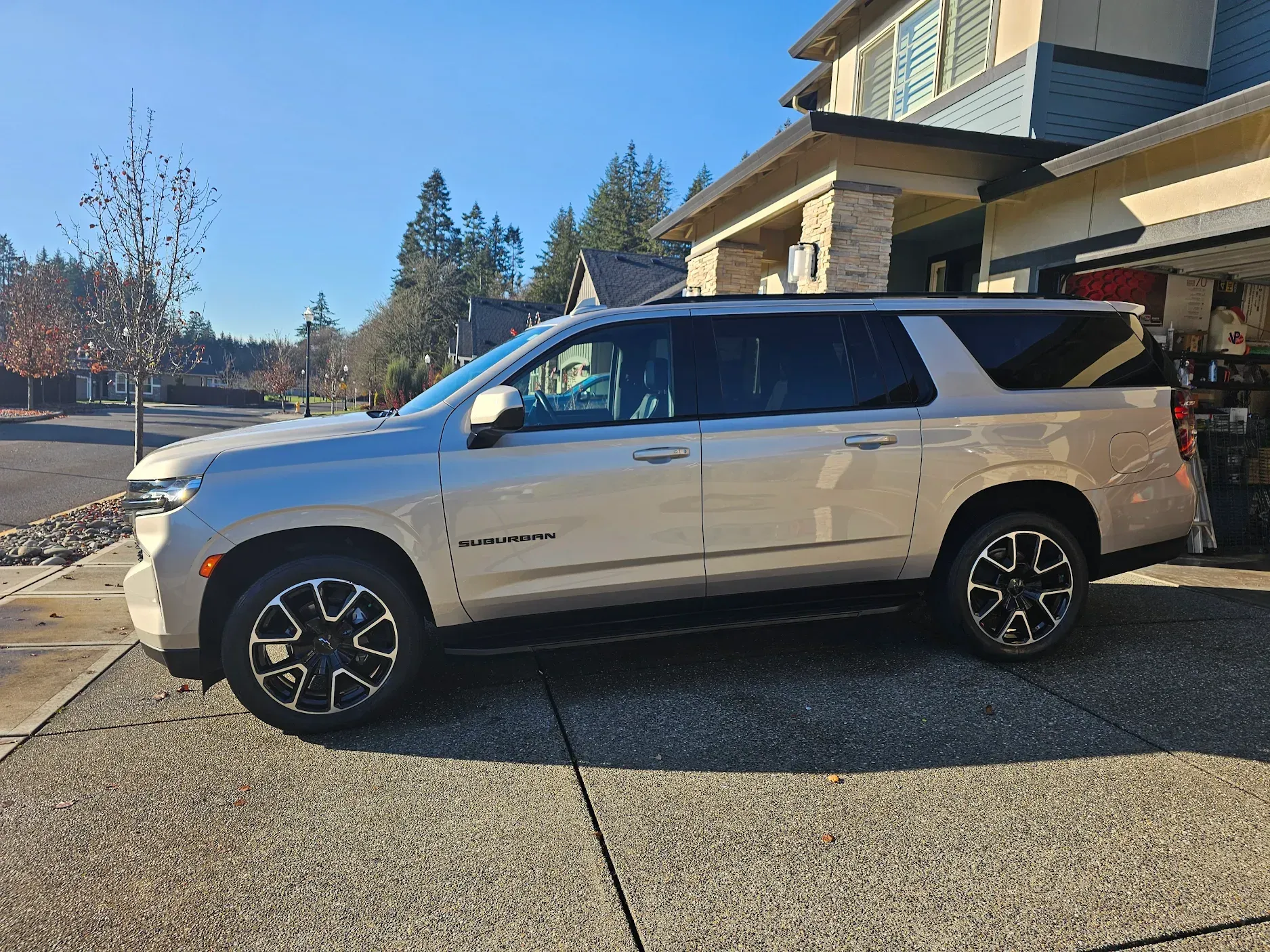 A silver suv is parked in front of a house.