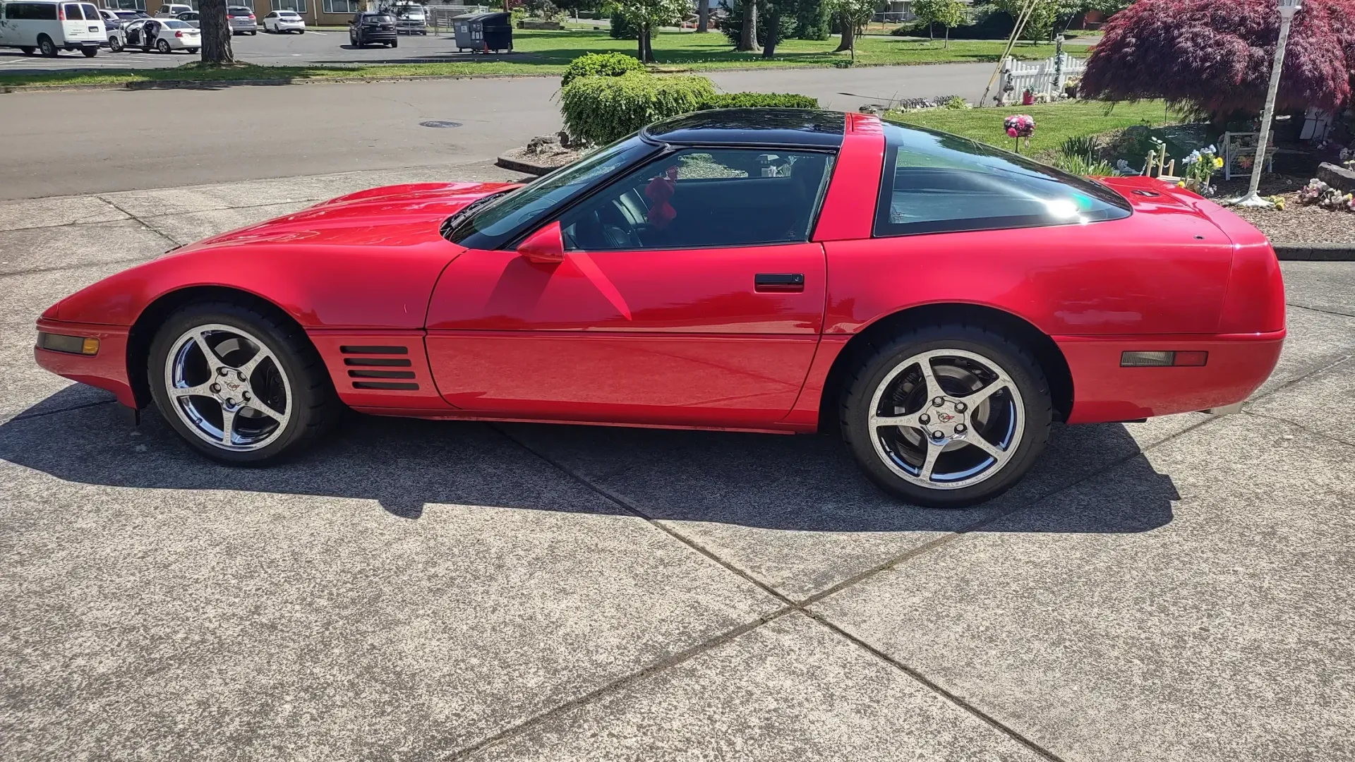 A red corvette is parked on the side of the road.