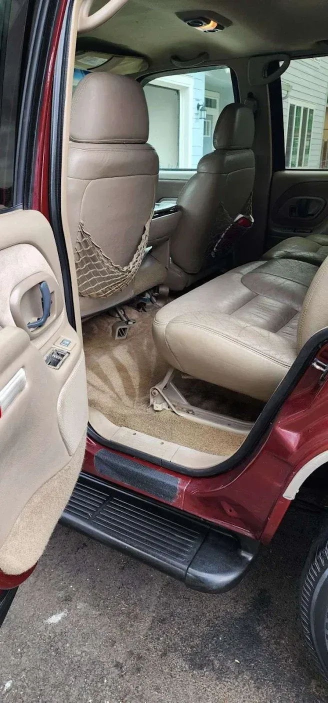 The inside of a red ford expedition with the door open.