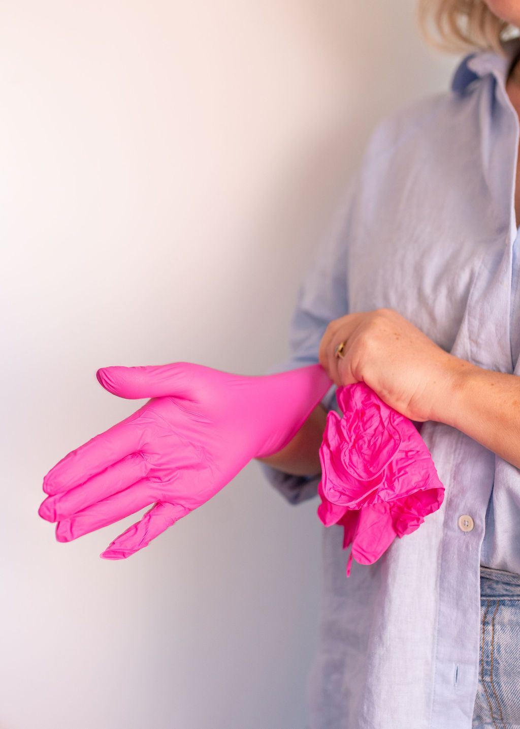 medical nurse putting on pink gloves