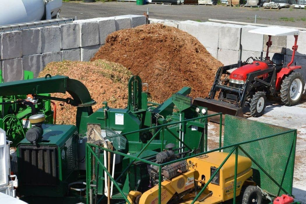 A Tractor is Parked in Front of a Pile of Wood Chips — Branch Manager Tree Services Coolum Beach In Narangba, QLD
