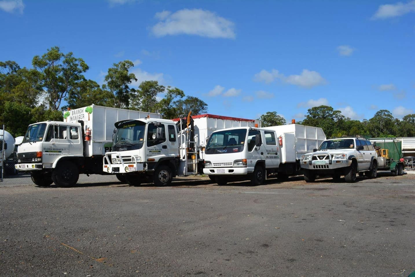 A Row Of White Trucks Are Parked In A Parking Lot — Branch Manager Tree Services Coolum Beach In Narangba, QLD