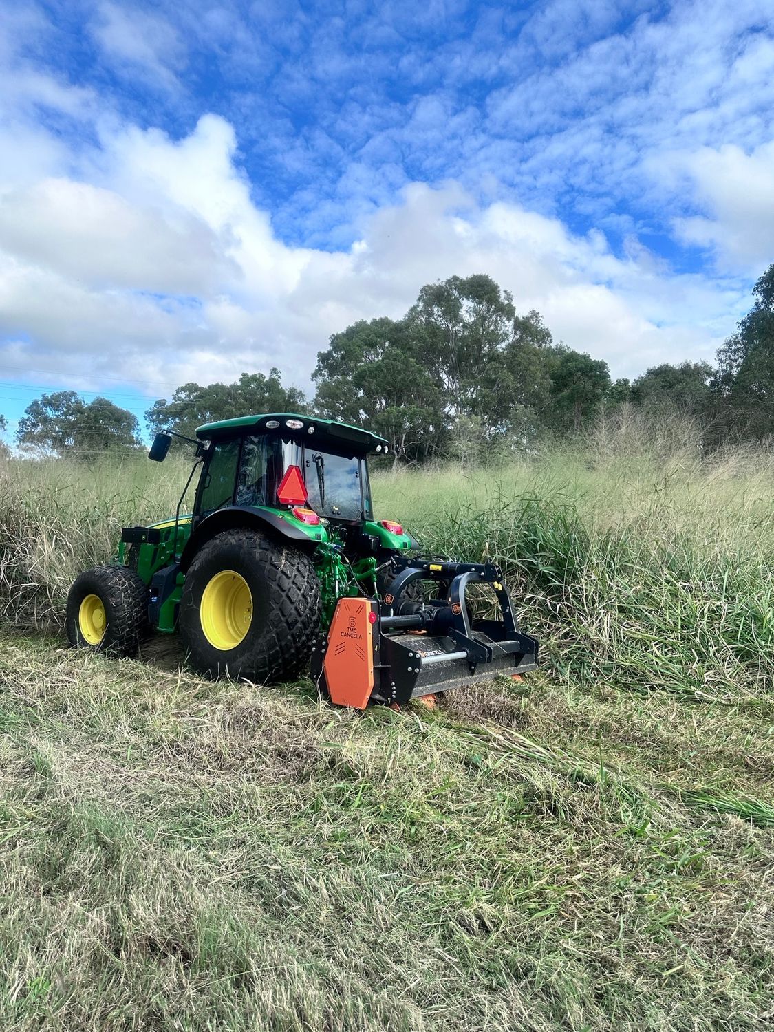 A Tractor Is Parked In Front Of A Pile Of Wood Chips — Branch Manager Tree Services Coolum Beach In Palmwoods, QLD