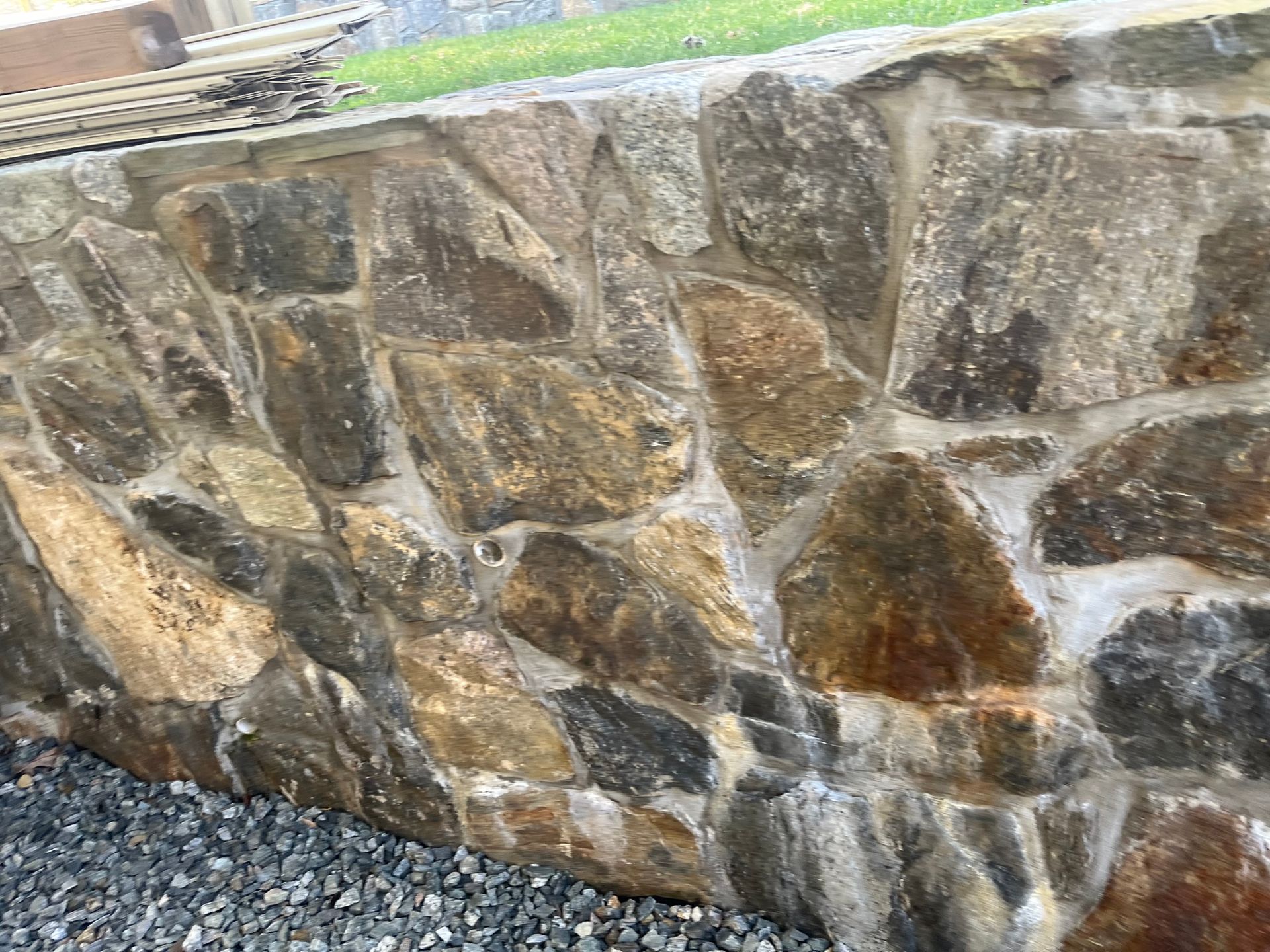 Bricklayer using a trowel to apply mortar and lay a brick for a wall.