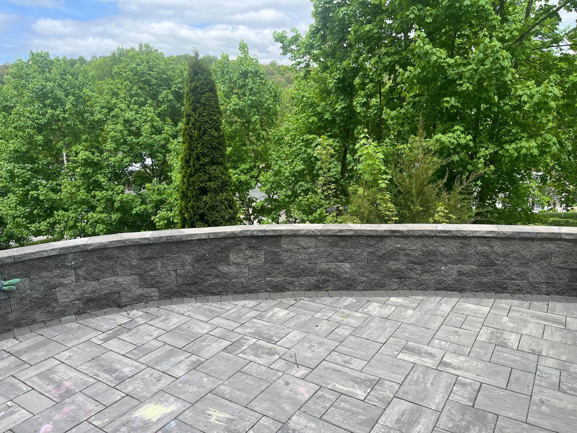 Stone facade, gray stones with dark grout, partially completed. Outdoors, daylight.