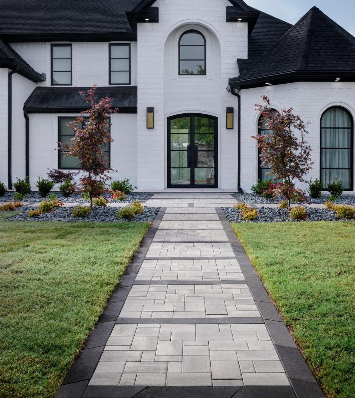 Stone pathway with large flat stepping stones, bordered by small stones and a rock border.