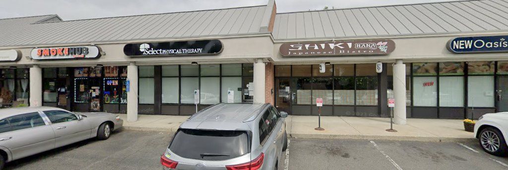 A parking lot with cars parked in front of a shopping center.