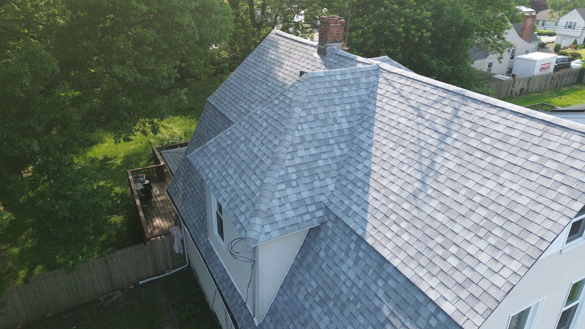 An aerial view of a house with a gray roof and a chimney.