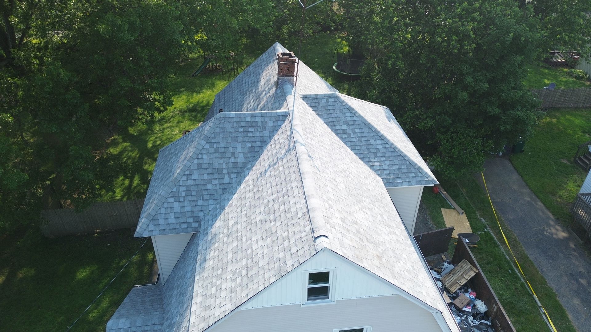 An aerial view of a white house with a gray roof.