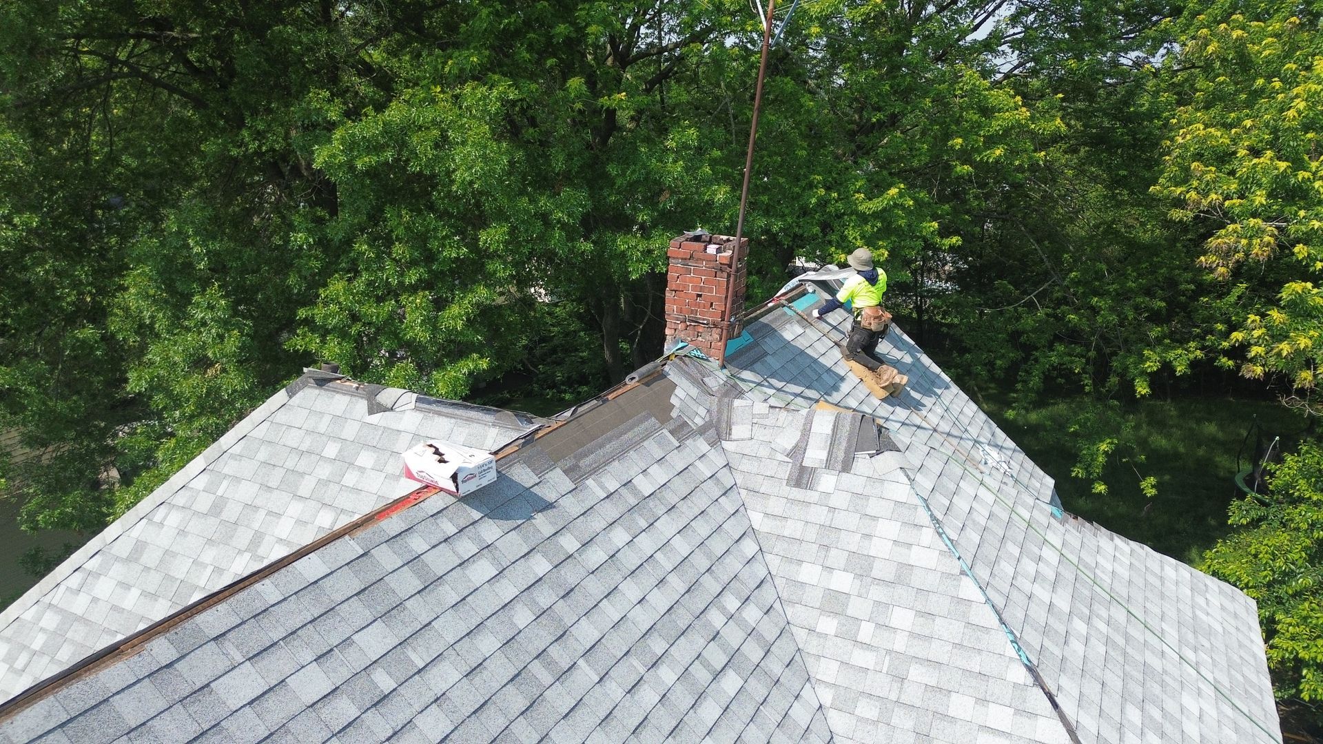 A man is working on the roof of a house.