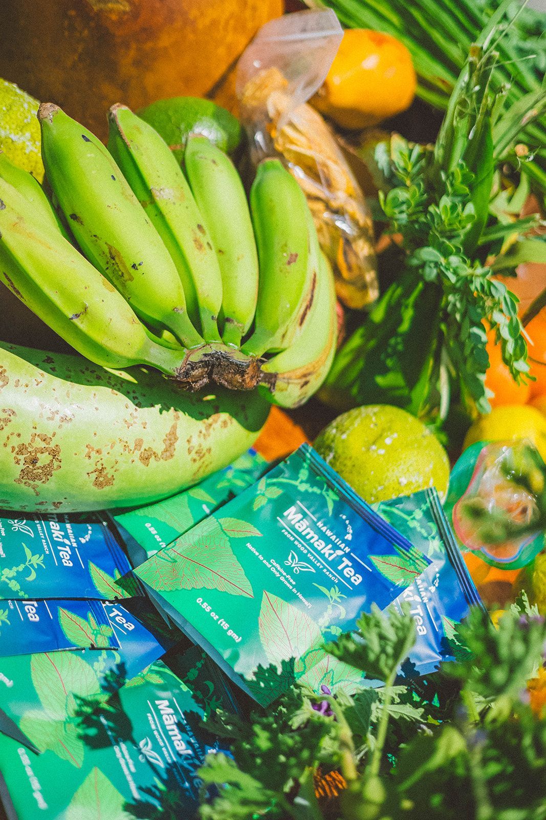 Assorted tropical produce including bananas and green leaves on a colorful market display