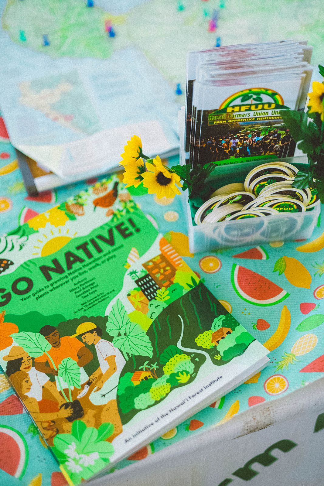 Reusable tote, book, and packaged plant-based snack on a colorful patterned tablecloth.
