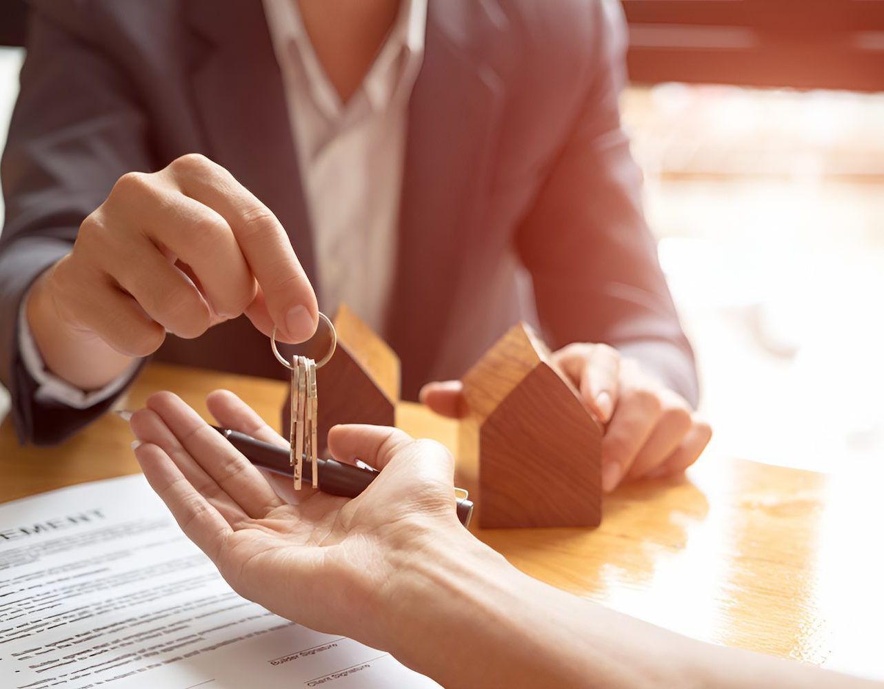 A Man Is Handing A Woman A Set Of Keys — Loretta Davison Financial Solutions In Thirroul, NSW 