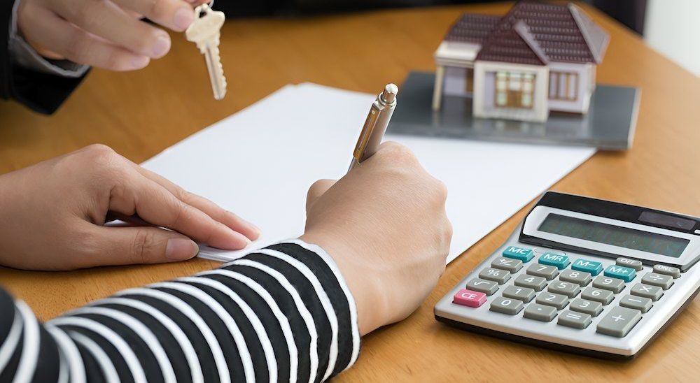 A Person Is Writing On A Piece Of Paper Next To A Calculator — Loretta Davison Financial Solutions In Shellharbour, NSW 