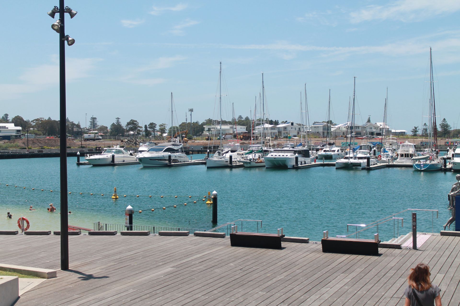 The Sun Is Setting Over A Body Of Water With Buildings — Loretta Davison Financial Solutions In Shellharbour, NSW 