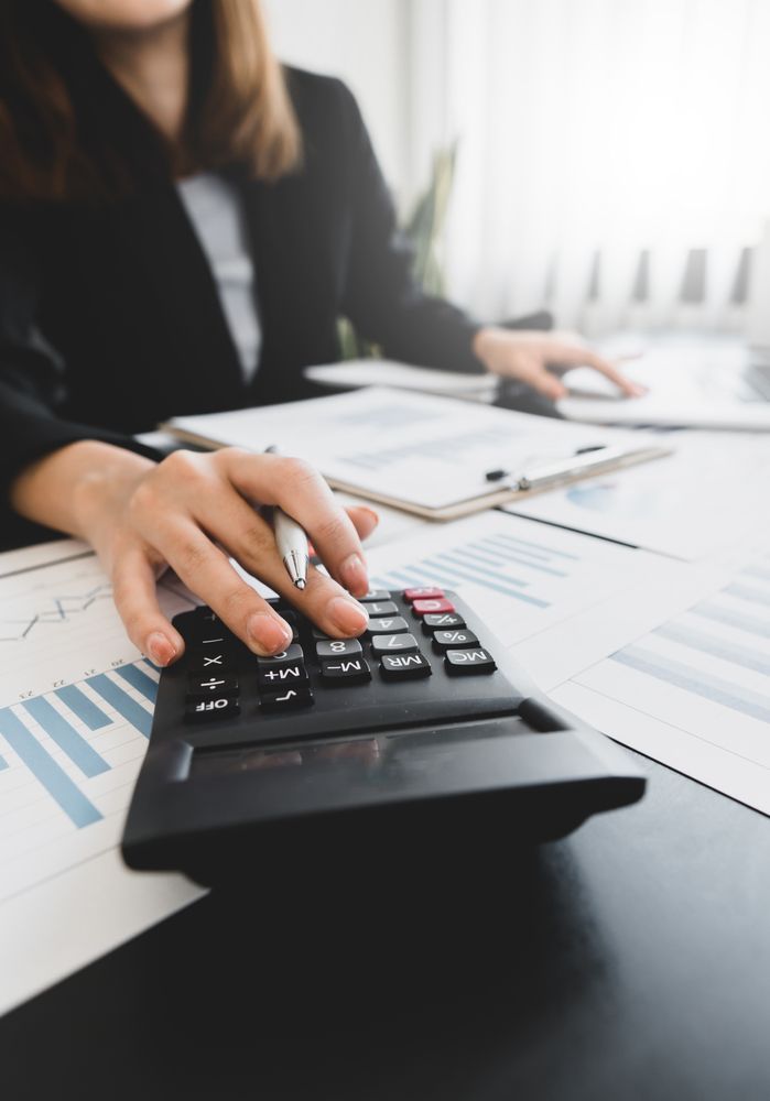 A Man In A Suit Is Looking At A Clipboard In A Living Room — Loretta Davison Financial Solutions In Wollongong, NSW 