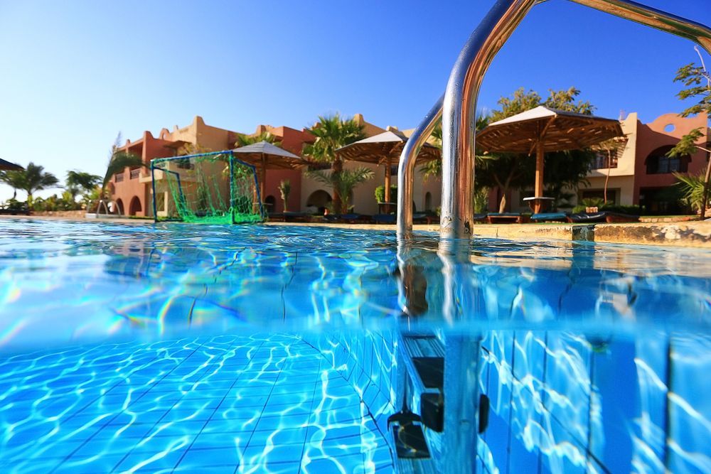 A Swimming Pool with Stairs Leading to It and A Building in The Background —
Whitsunday Pool Service in Cannonvale, QLD