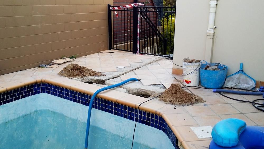 A Swimming Pool is Being Remodeled With a Hose Attached to the Edge — Whitsunday Pool Service in Cannonvale, QLD
