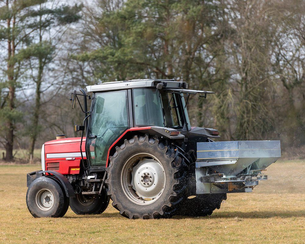 Red Tractor with Lime Spreader — Sparta, WI — Wayne Bohl Trucking LLC