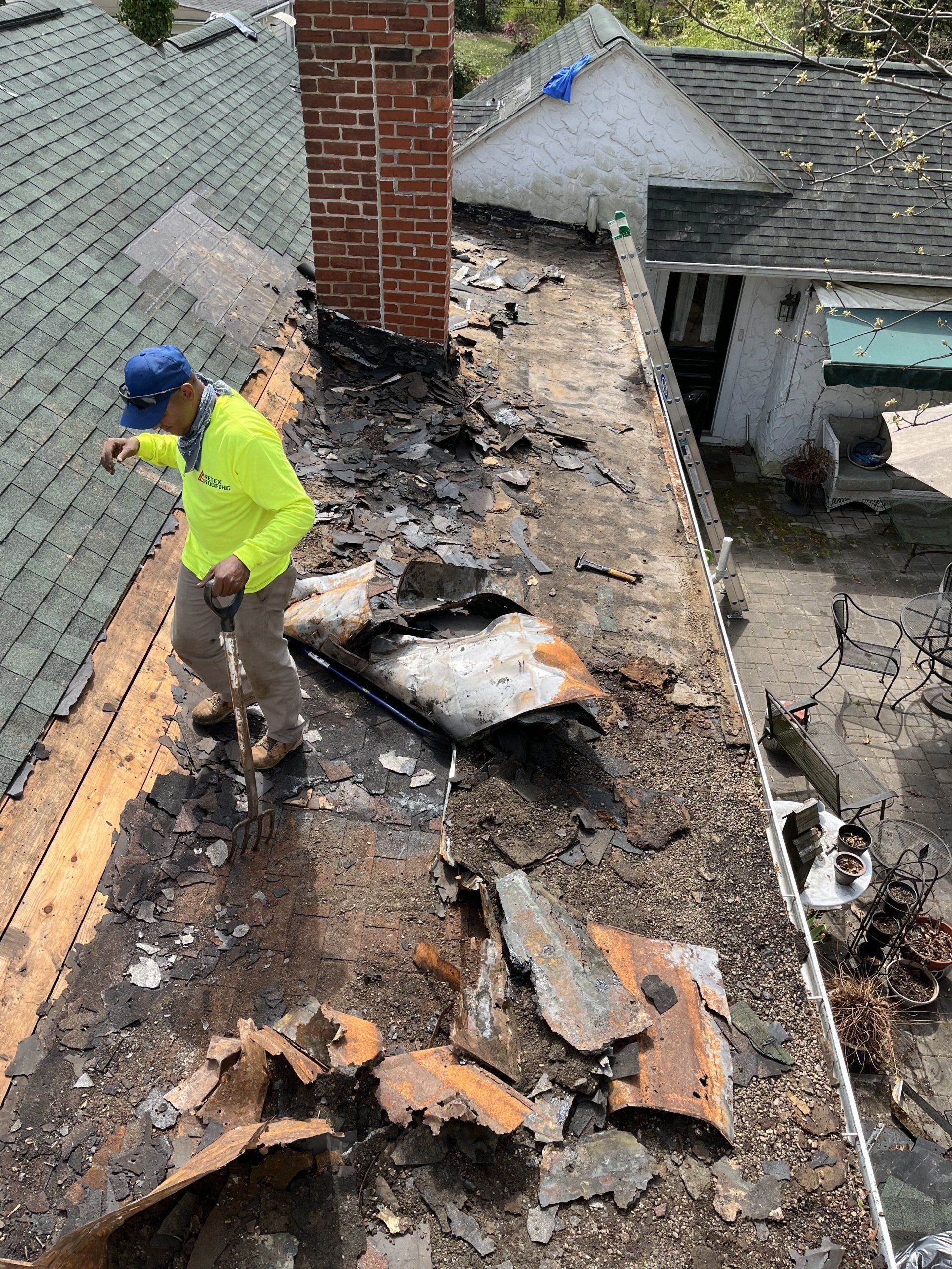 Image of flat roof replacement in Midlothian VA, with RETEX's Julio Marin removing the old flat roof. 
