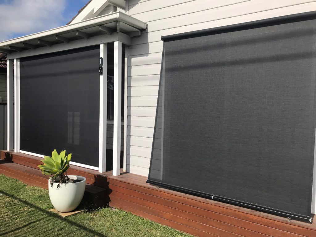 A window with a striped awning on it — Winning Blinds in Cardiff, NSW