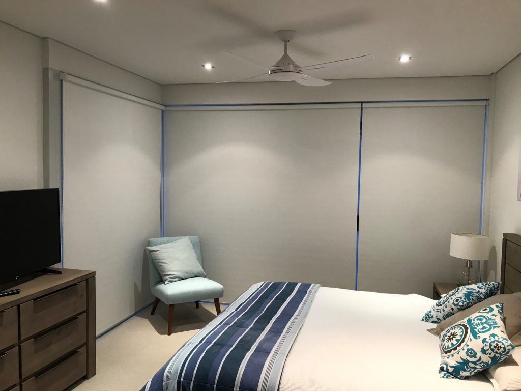 A Bedroom with A Bed, Chair, Dresser, and Television — Winning Blinds in Nelson Bay, NSW