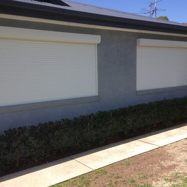 Exterior Of A House With Windows Covered By White Roller Shutters — Winning Blinds in Cardiff, NSW
