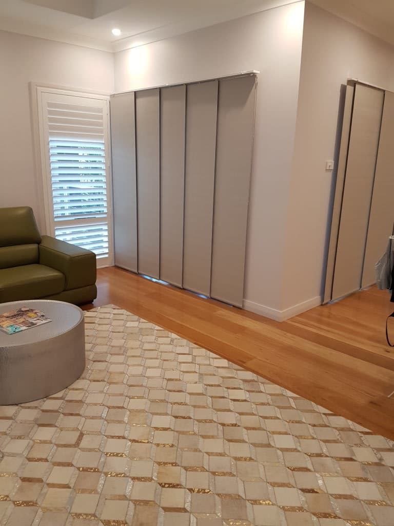 A Living Room with A Couch, Coffee Table, Rug, and Sliding Doors — Winning Blinds in Cardiff, NSW