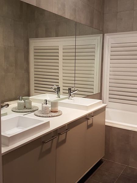 Bathroom With Double Sinks, Large Mirror, And Shutters — Winning Blinds in Cardiff, NSW