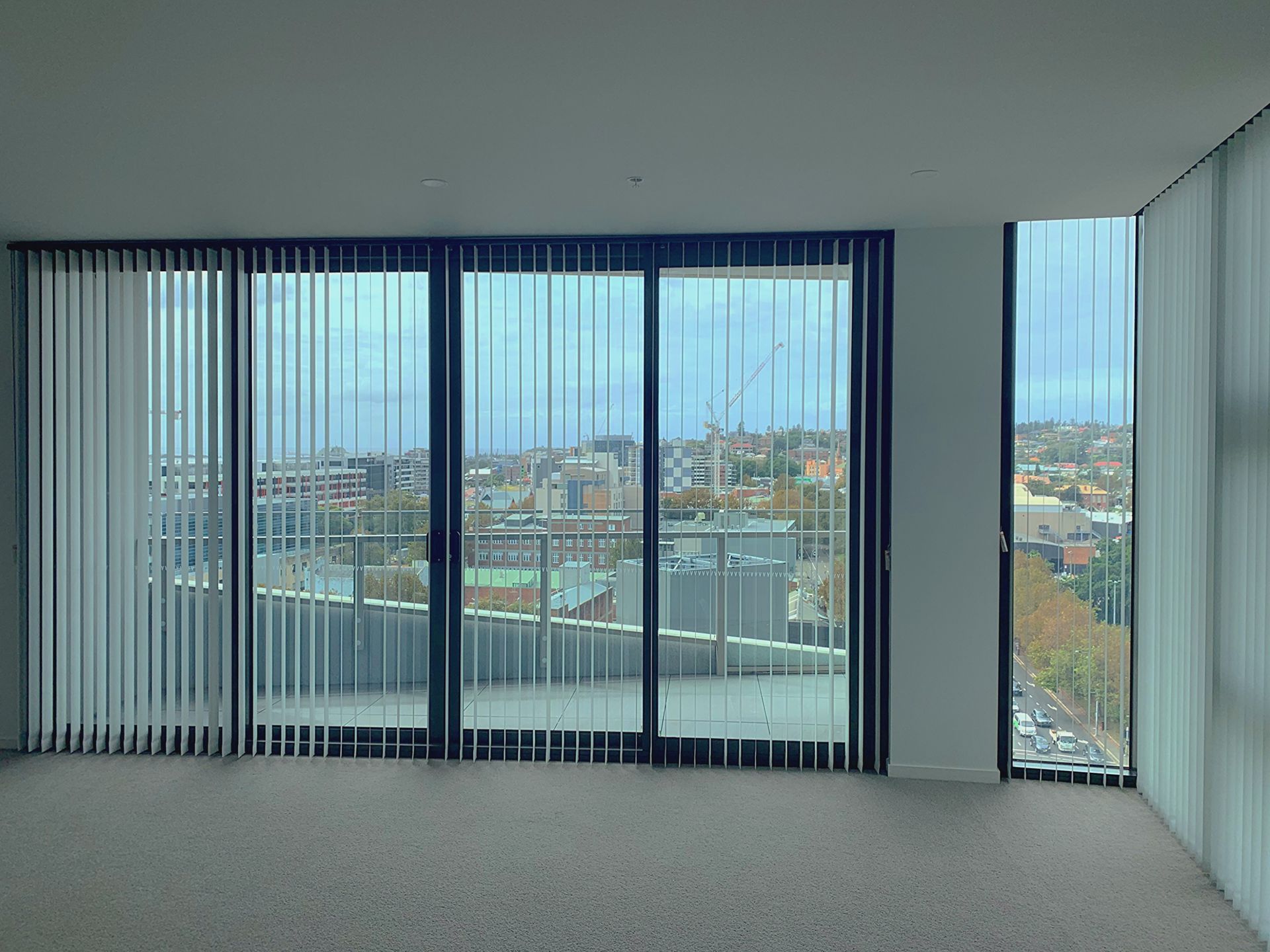 A Room With Vertical Blinds Overlooks The City